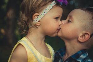 two young children kiss